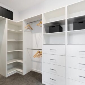 A white closet with many drawers and shelves.