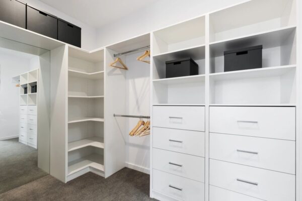 A white closet with many drawers and shelves.