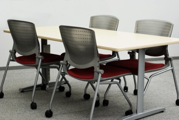 A table and chairs in front of a wall.