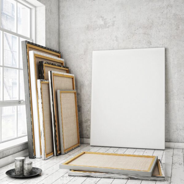 A room with several paintings and frames on the floor.